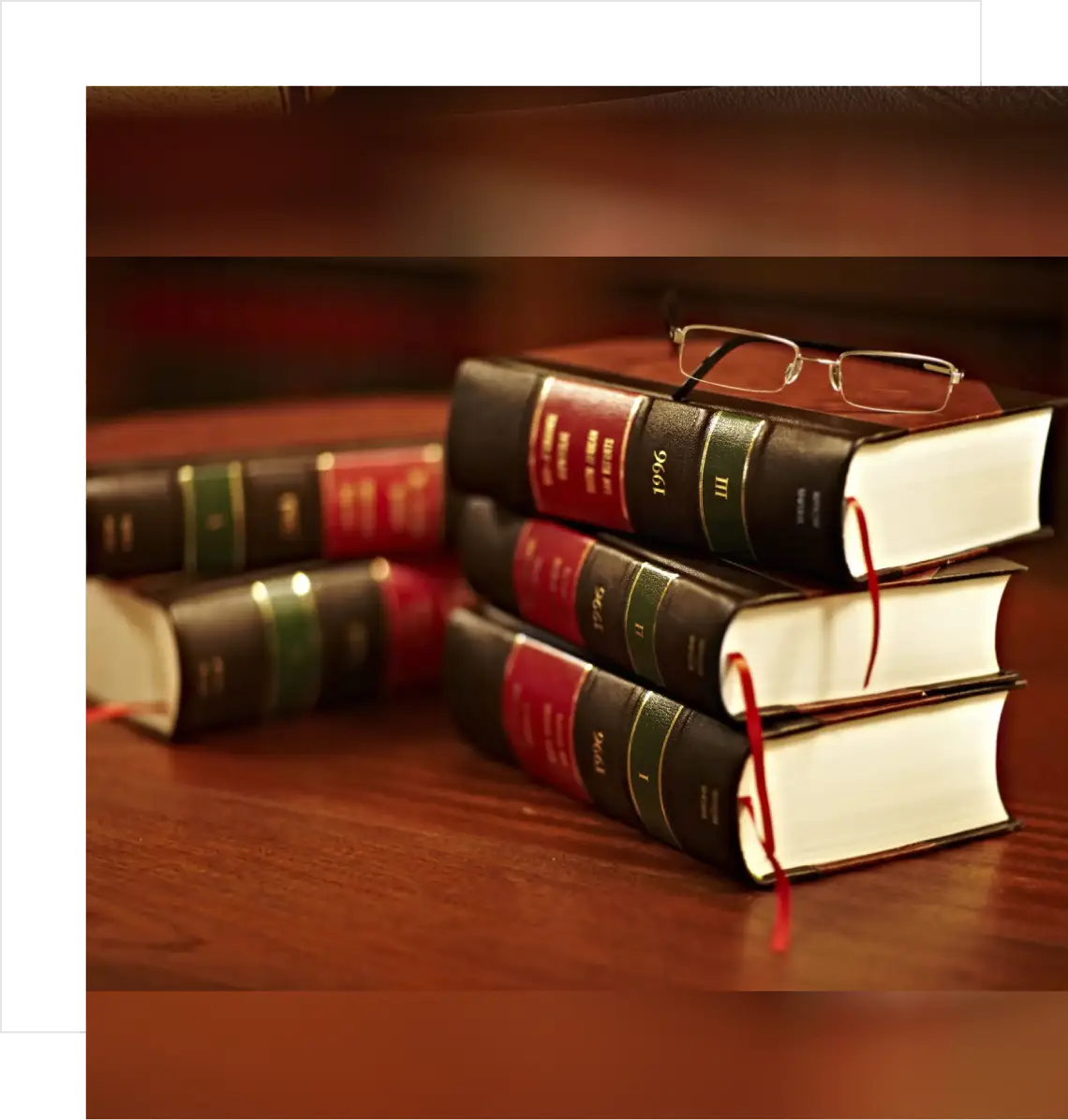 Stack of law books with glasses on top.