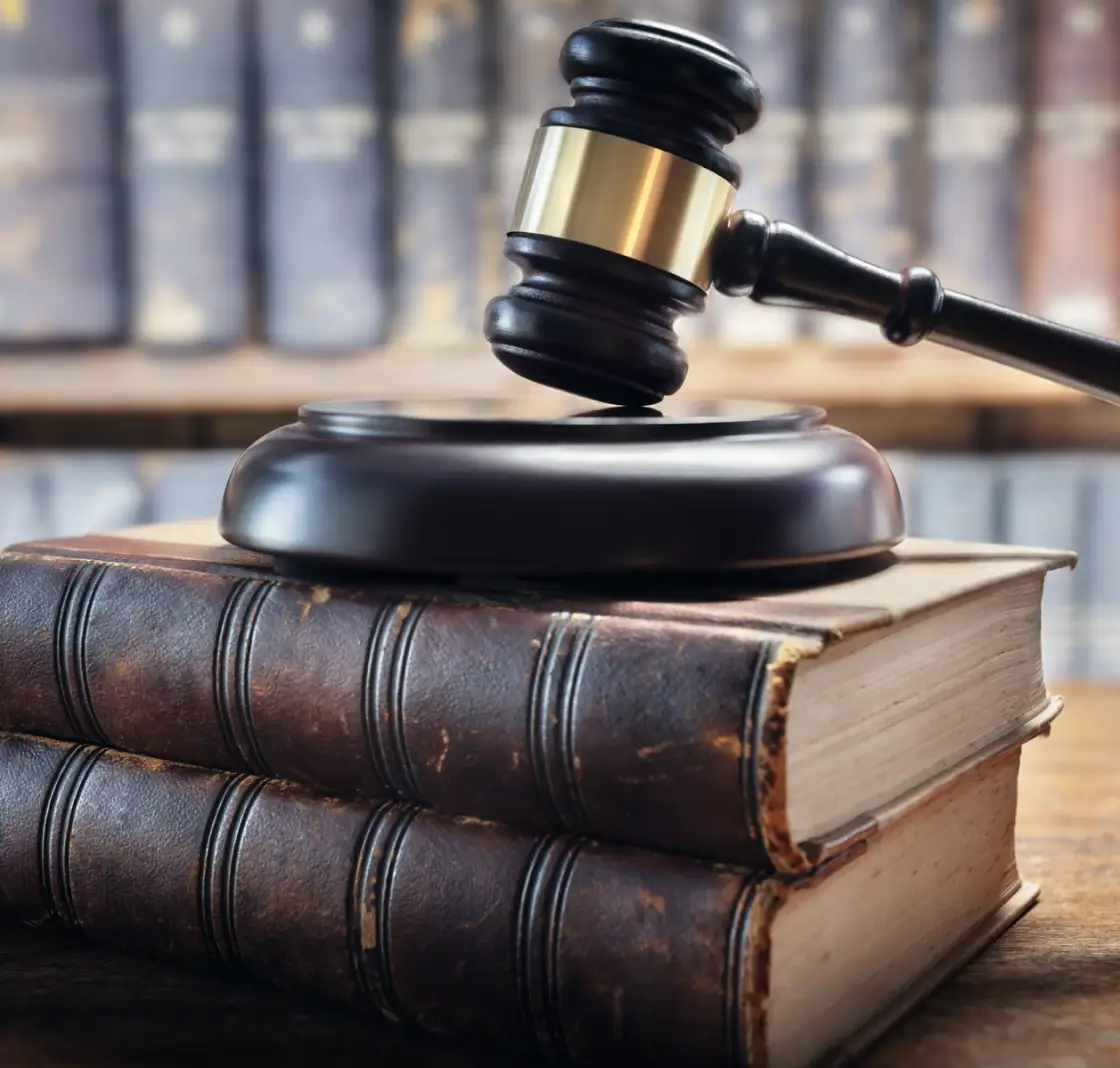 Gavel on stacked law books in library.