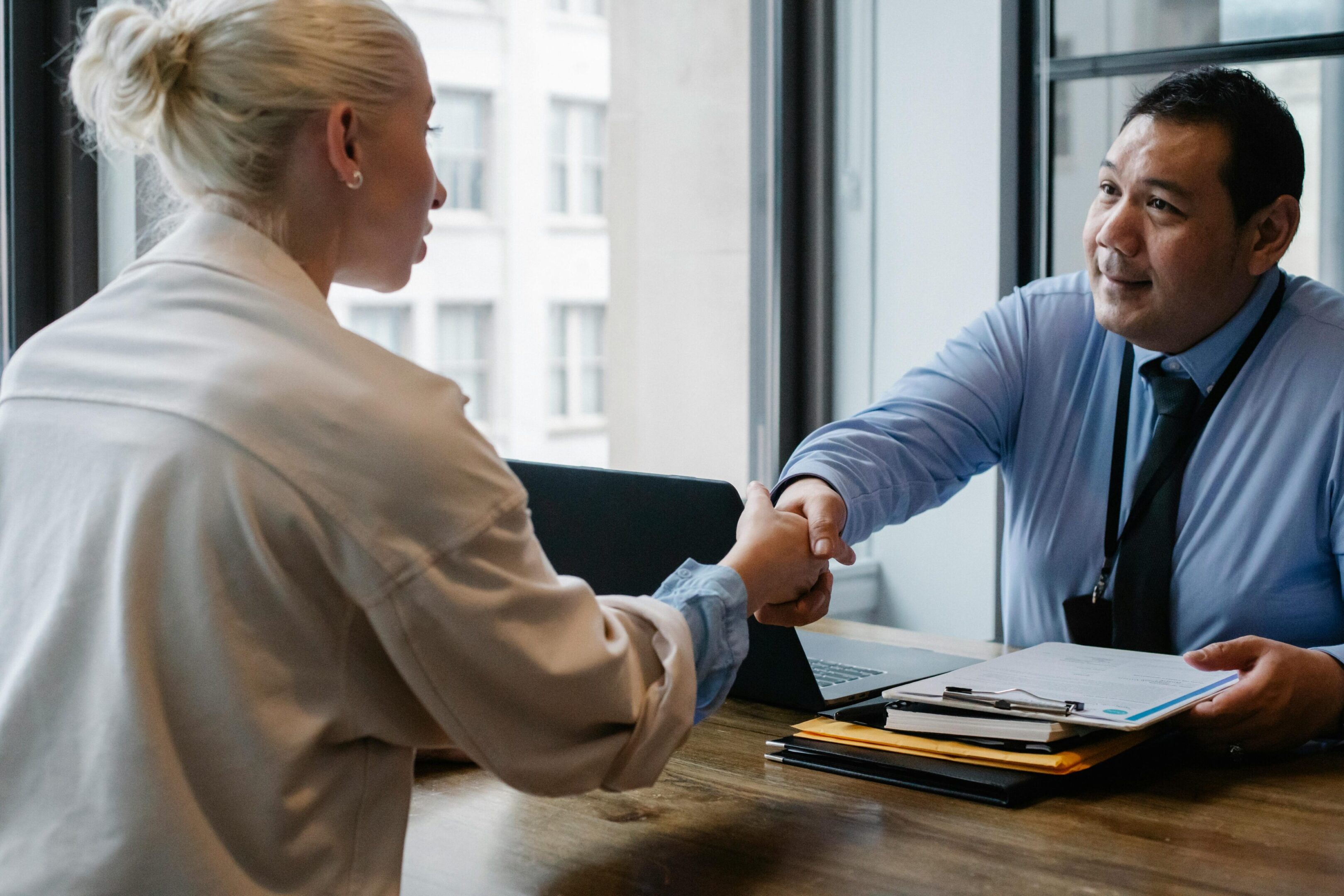 Two people shaking hands in an office.