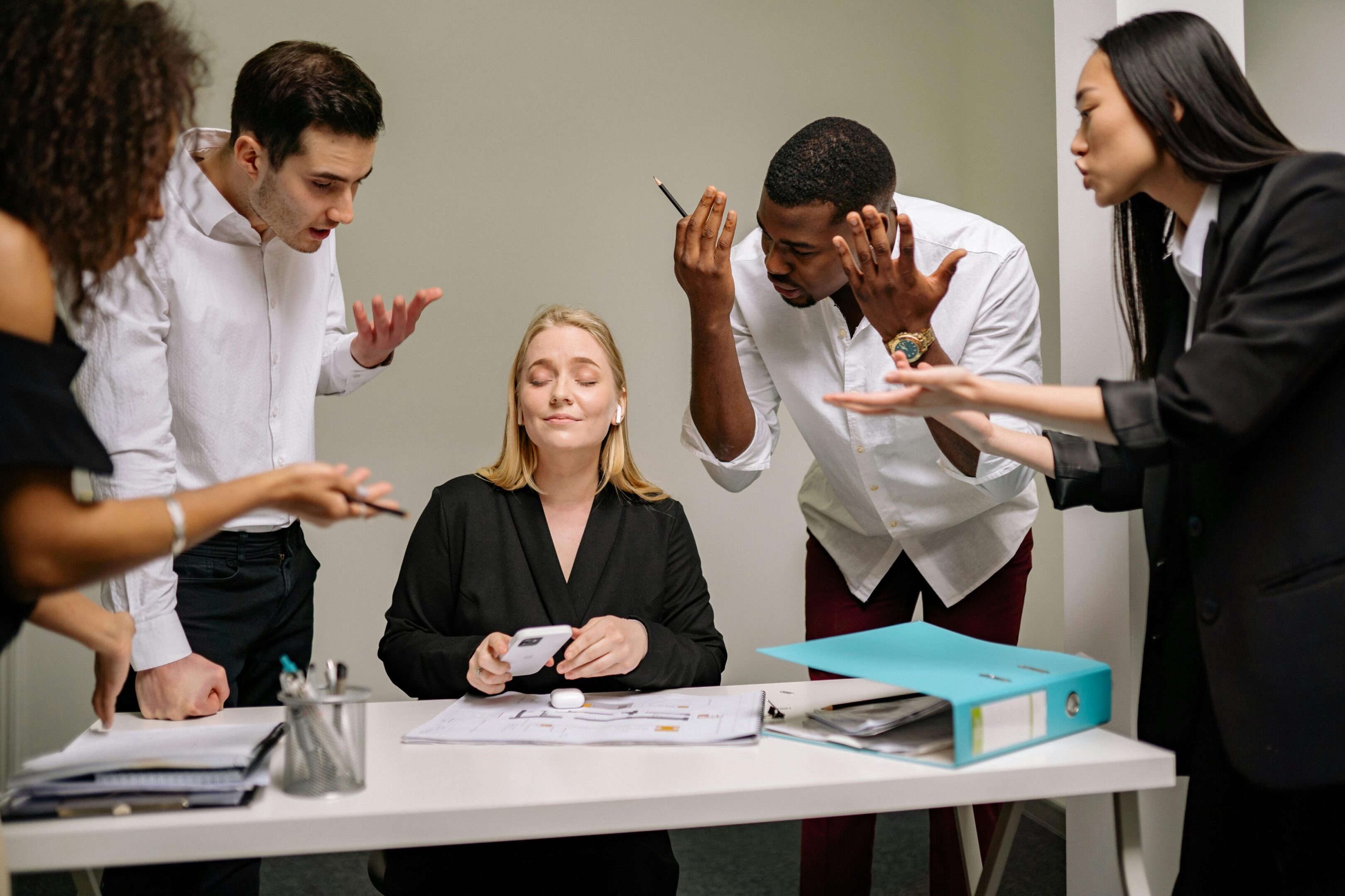 Team discussing with a woman at desk.