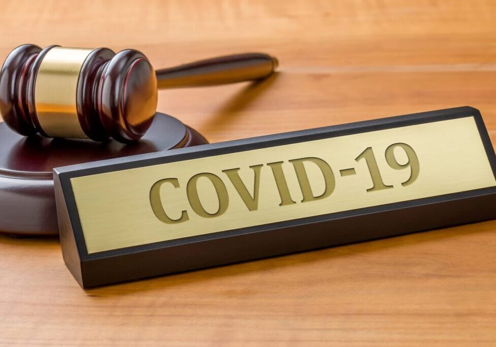Gavel next to COVID-19 nameplate on table.